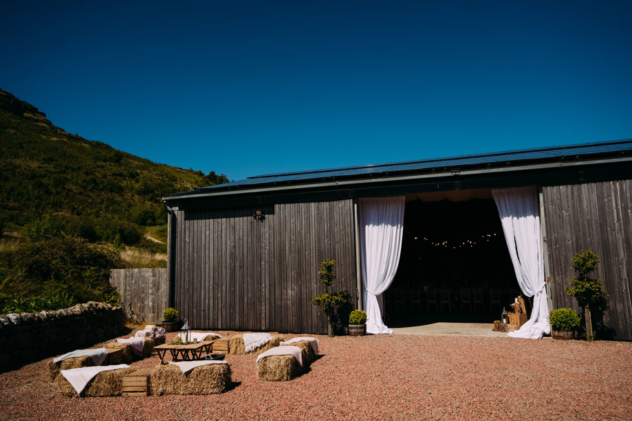 Barn entrance with hay bale seats outside